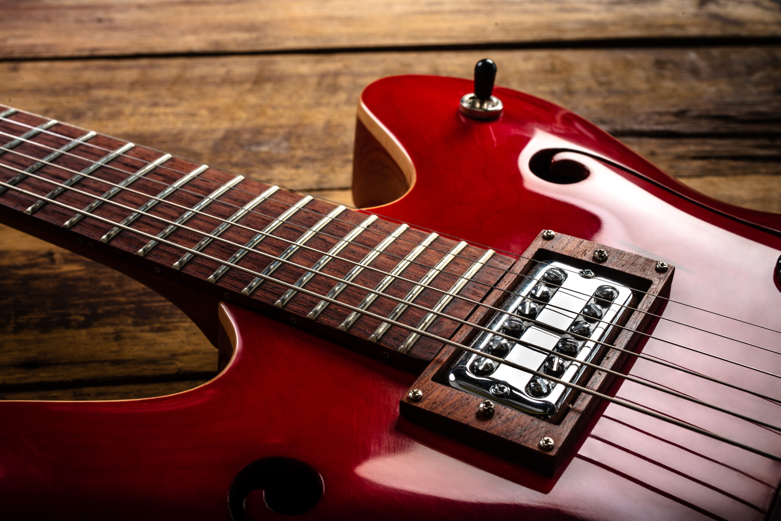 guitarra electrica roja sobre suelo madera scaled - KronalinE - K+E Output